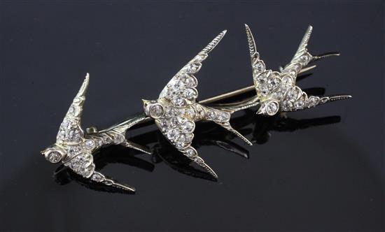 A gold and diamond set triple swallow brooch, 2.5in.